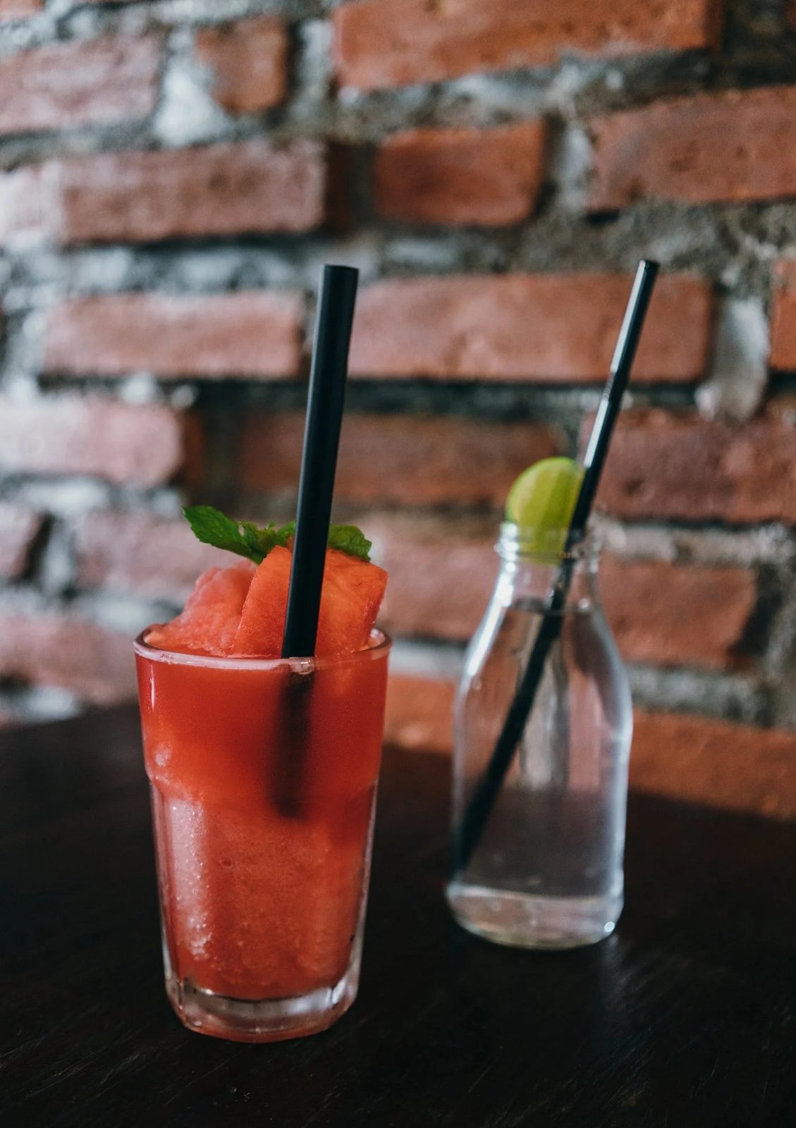 Watermelon Refresher — cold pressed, served against the brick wall