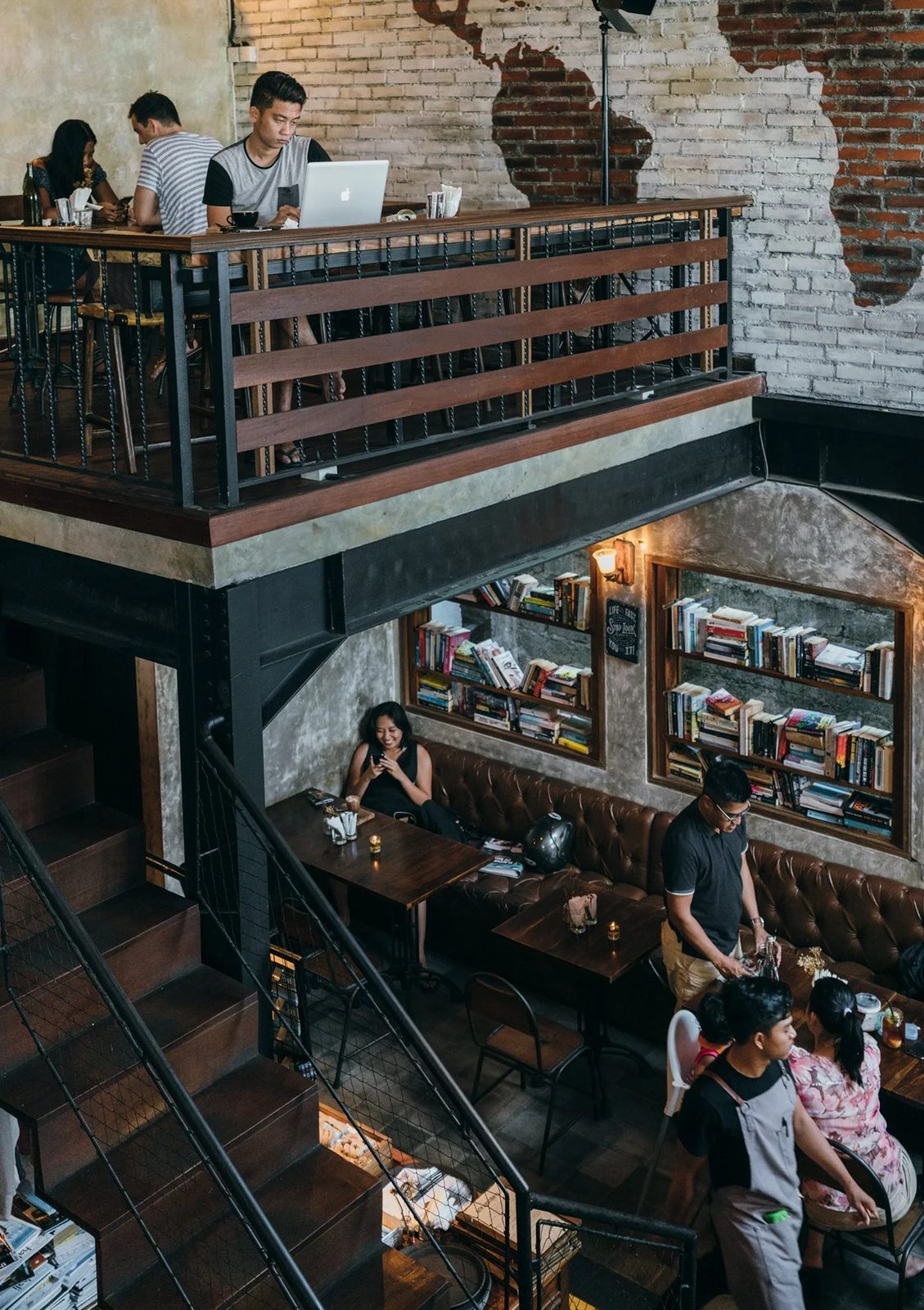 Pison Petitenget — mezzanine, leather banquettes, exposed brick wall with world map